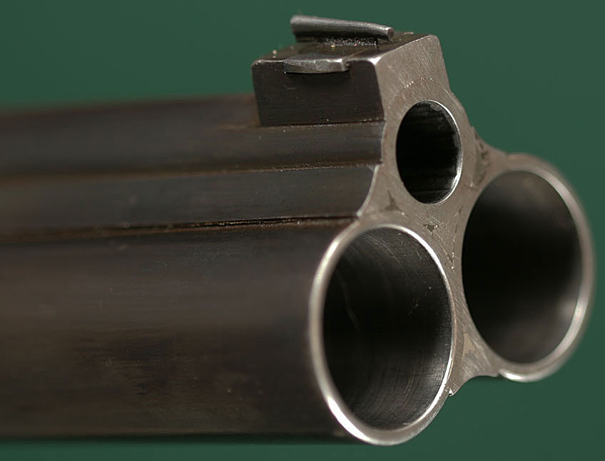 A three-barrel gun, typically with two identical side-by-side shotgun barre...